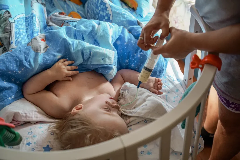 Мама Оксана Чукавина встаёт в&nbsp;полшестого утра и&nbsp;даёт дочке Полине с&nbsp;паллиативным диагнозом лекарства. Семья получает пособие по&nbsp;инвалидности, но&nbsp;специальное питание выходит дороже. Центр «Вместе» приобрели для семьи уголь и&nbsp;дрова на&nbsp;зиму, чтобы дети не&nbsp;оказались в&nbsp;учреждении. Фото: Дмитрий Яцюк.