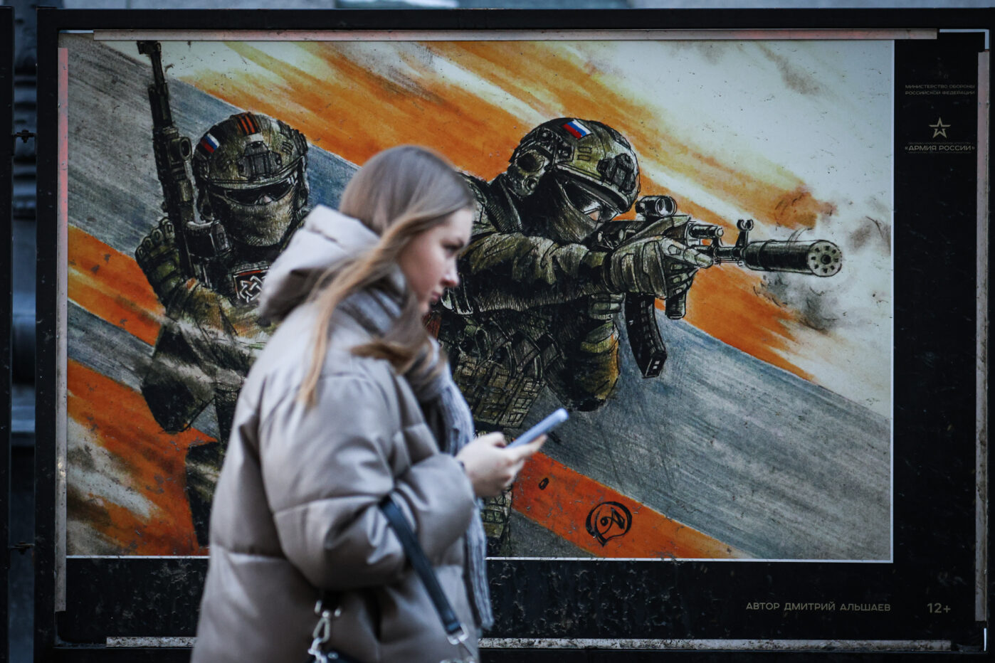 Девушка проходит мимо плаката с&nbsp;изображением российских военнослужащих на&nbsp;уличной выставке в&nbsp;Санкт-Петербурге