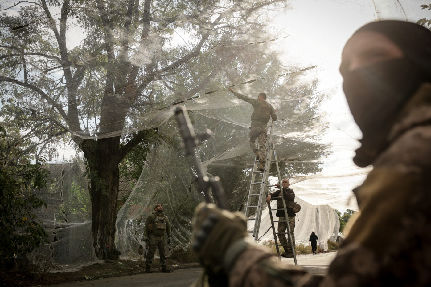 Военнослужащие Украины устанавливают противодронные сетки над дорогой в прифронтовом городе Константиновка Донецкой области